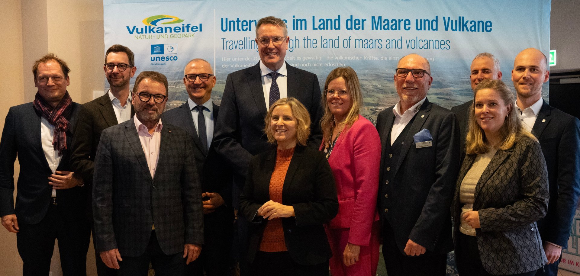 Foto v.l.n.r: Elmar Eich (Auswärtiges Amt, Berlin) Jens Jenssen (MdL, Daun), Wolfgang Treis (Präsident SGD Nord), Dr. Lutz Möller (Deutsche UNESCO Kommission, Bonn), Alexander Schweitzer (Ministerpräsident Rheinland-Pfalz), Katrin Eder (Klimaschutzministerin Rheinland-Pfalz), Julia Gieseking (Landrätin Landkreis Vulkaneifel), Dr. Andreas Schüller (Geschäftsführer Natur- und Geopark Vulkaneifel), Dennis Junk (MdL, Wittlich), Dr. Susanne Scheppe (Vertr. für MdL Gordon Schnieder, Daun) und Thomas Scheppe (Bürgermeister VG Daun). © Natur- und Geopark Vulkaneifel, Scholzen