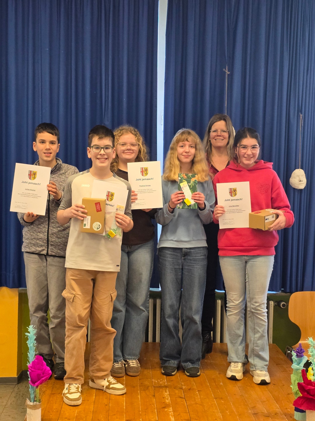 Jonas Umbach (Zweiter von links) hat 2026 den Mundartwettbewerb der Sechstklässler im Landkreis Vulkaneifel gewonnen. Die weiteren Teilnehmer waren (von links) Julian Kumar, Paulina Harnau, Hermine Zutz und Jule Devolder. Landrätin Julia Gieseking (Zweite von rechts) nahm die Siegerehrung vor.