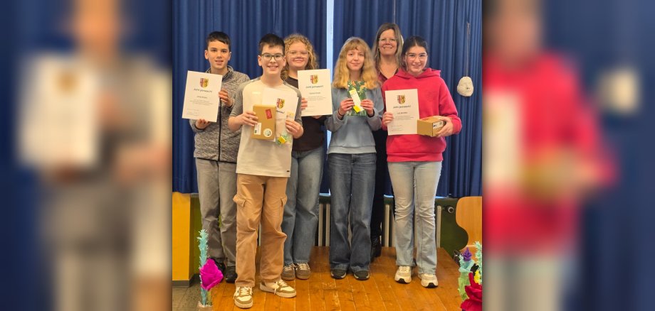 Jonas Umbach (Zweiter von links) hat 2026 den Mundartwettbewerb der Sechstklässler im Landkreis Vulkaneifel gewonnen. Die weiteren Teilnehmer waren (von links) Julian Kumar, Paulina Harnau, Hermine Zutz und Jule Devolder. Landrätin Julia Gieseking (Zweite von rechts) nahm die Siegerehrung vor.